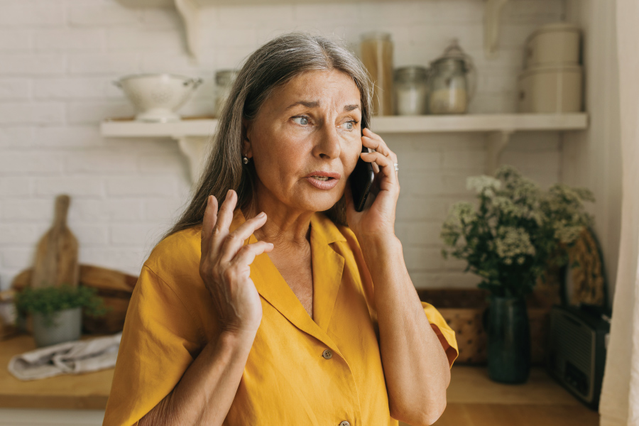 A women with a concerned expression talking on the phone