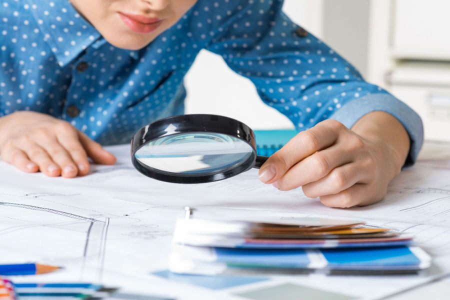 woman looking at documents with a magnifying glass