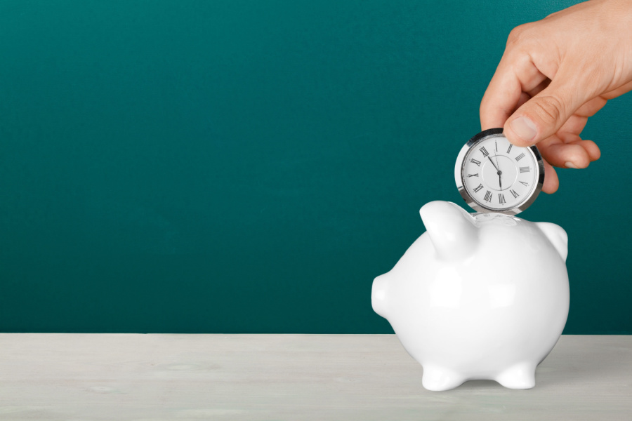 man putting a pocket watch in a piggy bank