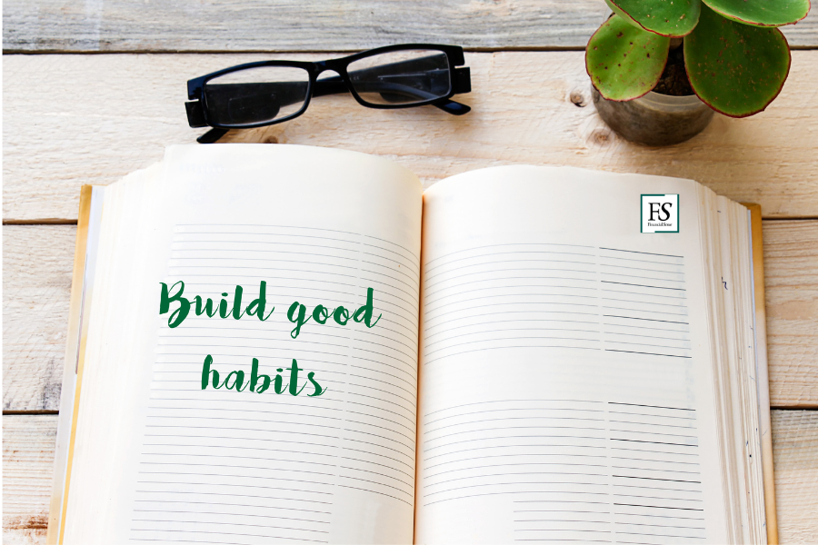 open notebook on a desk that reads "build good habits"