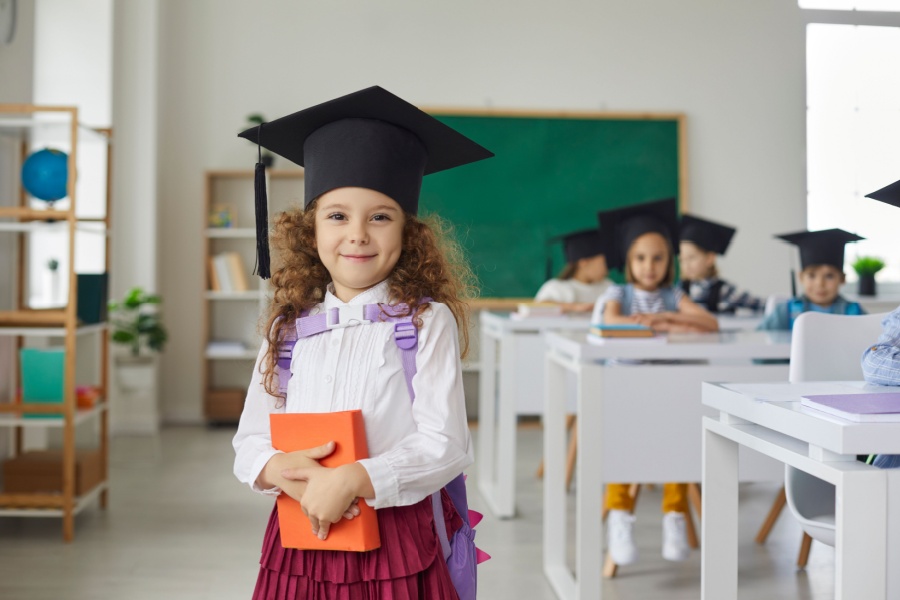 preschool girl wearing graudation hat in her classroom